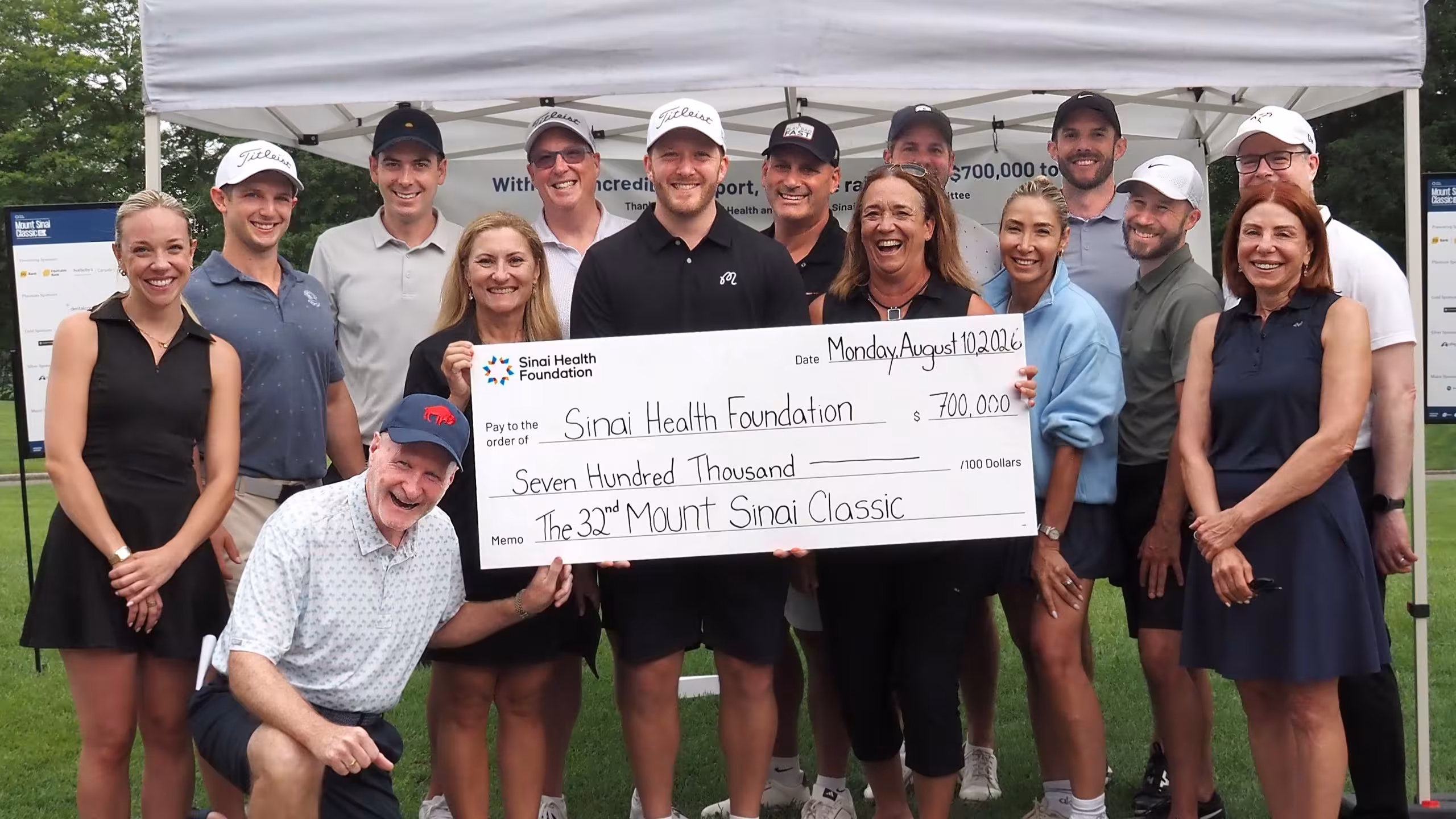 group stands with big cheque