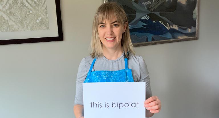 image of woman holding a sign that says 'this is bipolar'