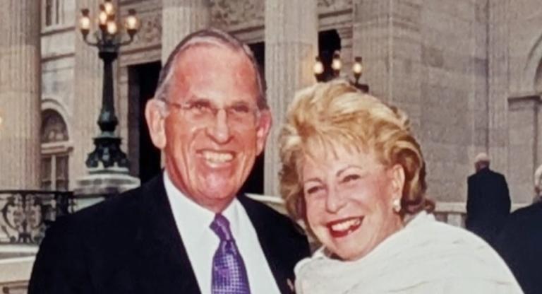 Smiling man and woman. Red banner with white text reads Jerry and Carole Grafstein