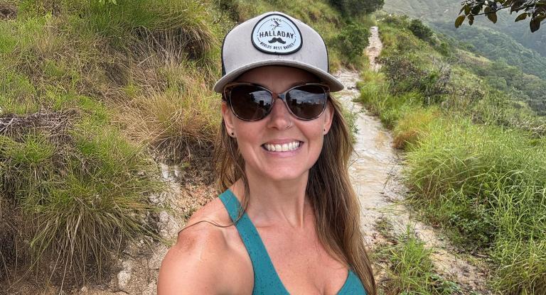 Woman hiking outside, wearing sunglasses