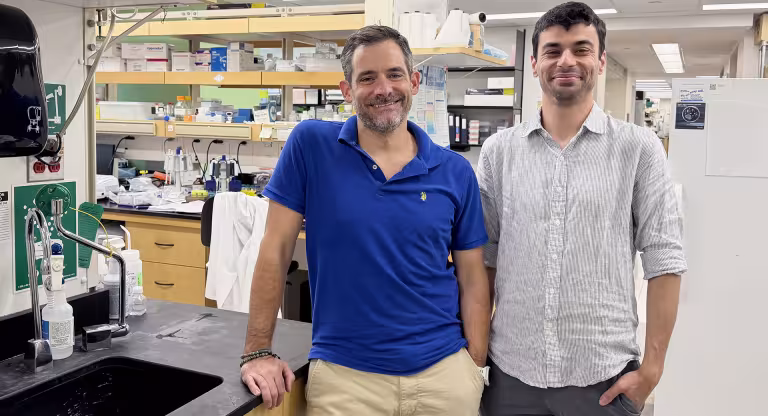 Drs. Daniel Schramek on the left and Khalid Al-Zahrani on the right standing in a scientific lab setting.