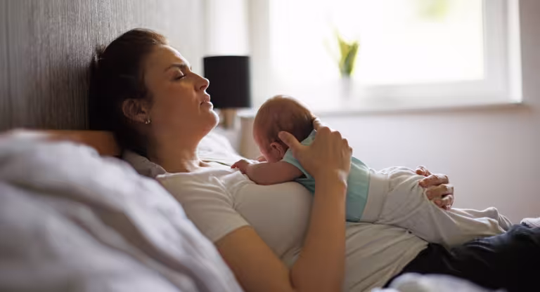 woman holding baby on chest