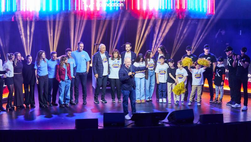large group stands on stage, celebrating their win