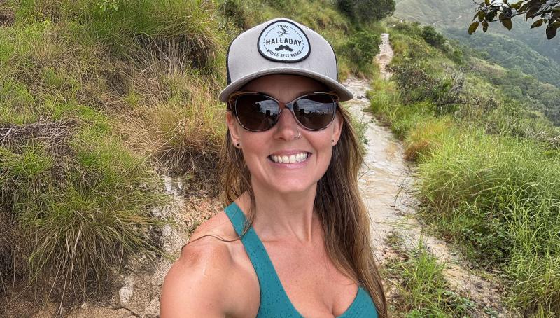 Woman hiking outside, wearing sunglasses