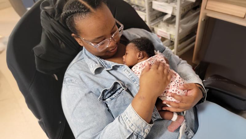 mother holds tiny baby against her chest