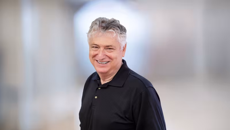headshot of man wearing black shirt
