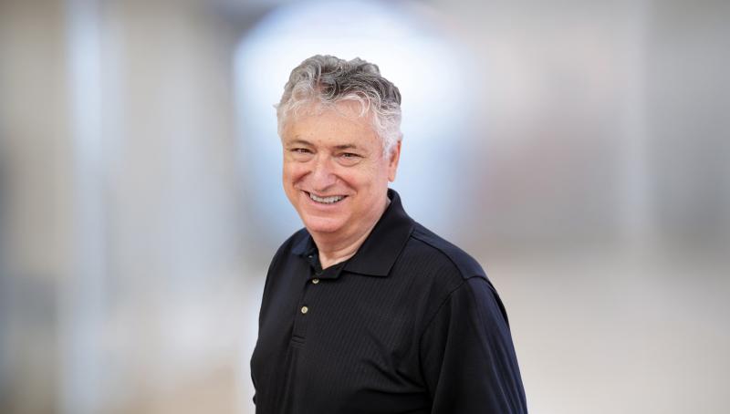 headshot of man wearing black shirt