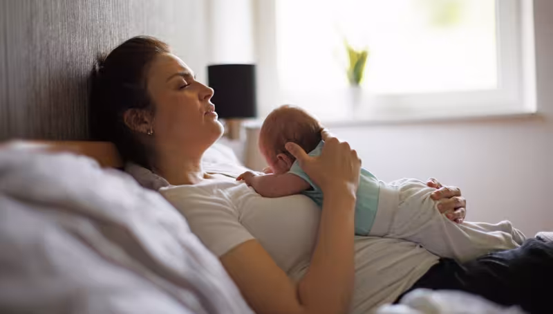 woman holding baby on chest