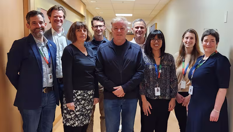 A team of researchers from Sinai Health and the University of Toronto standing in a hallway together smiling. 