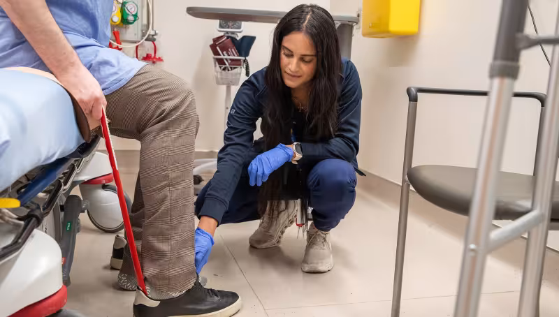 Occupational therapist Stephanie Seilman helps a Mount Sinai Emergency Department patient use a long-handled shoehorn.