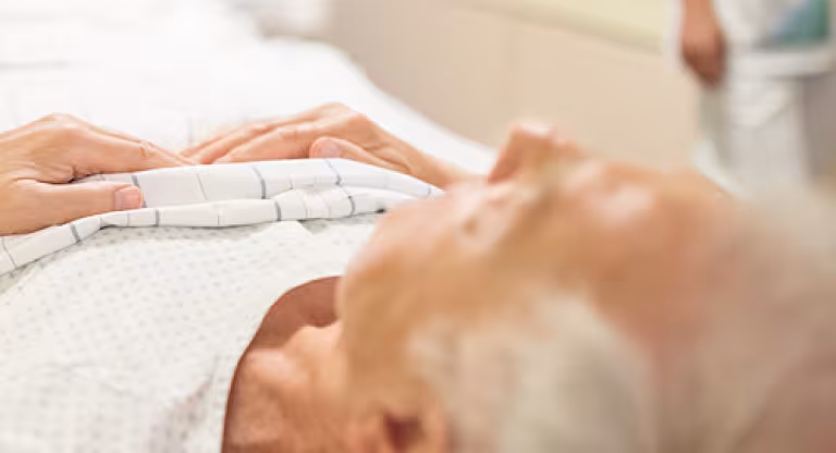 A senior man lying in a hospital bed
