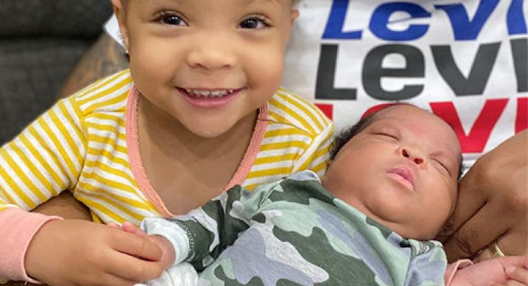 A toddler and her baby brother