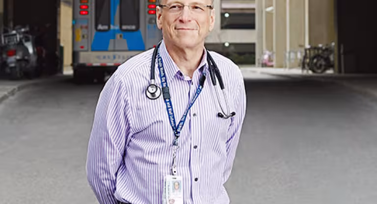 Man standing outside with an ambulance in the background