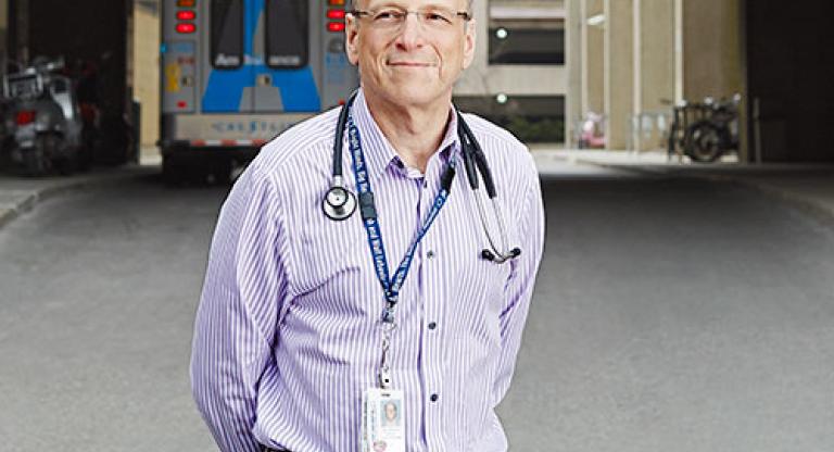 Man standing outside with an ambulance in the background