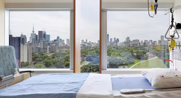 A panoramic view of the city skyline through large windows of hospital room