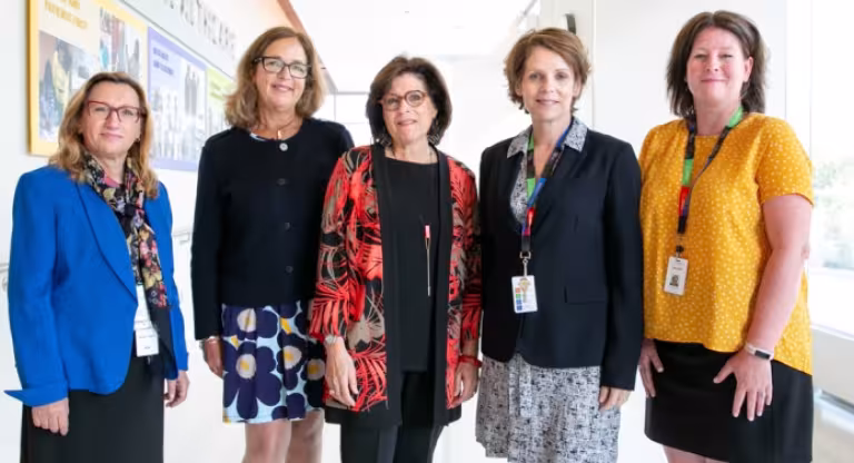 Five women standing in the Hennick Bridgepoint hallway. 