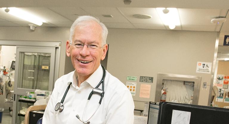 A head shot of a man wearing a stethoscope in a clinic