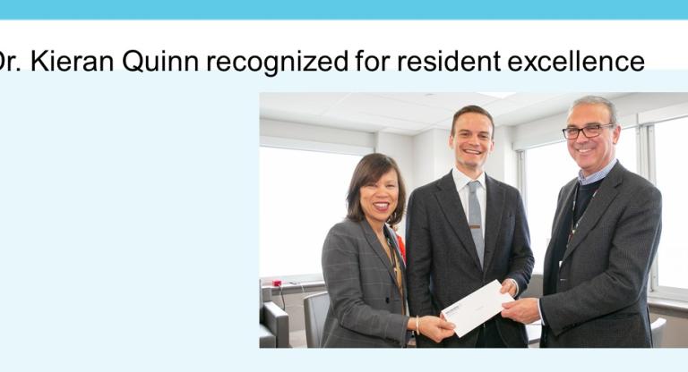 Three people pose with an envelope