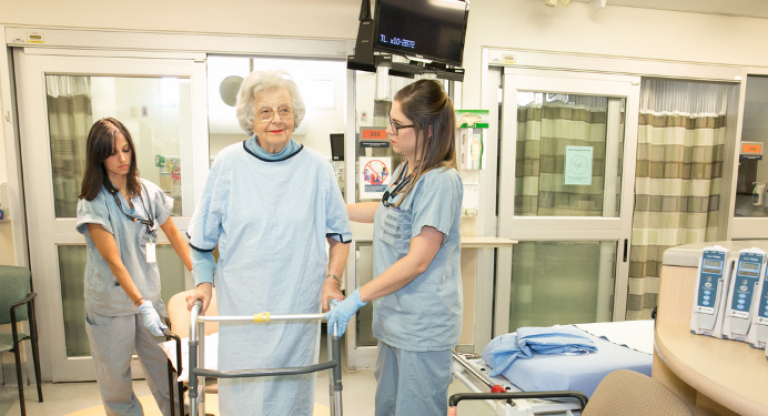 Older adult walks with assistive device