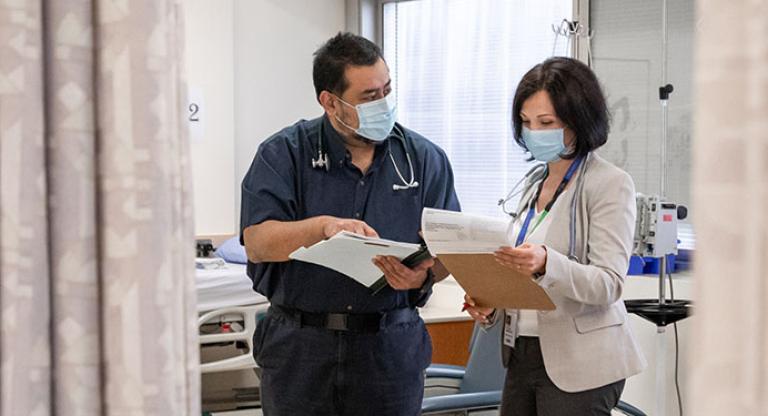 Two healthcare workers standing and reviewing documents