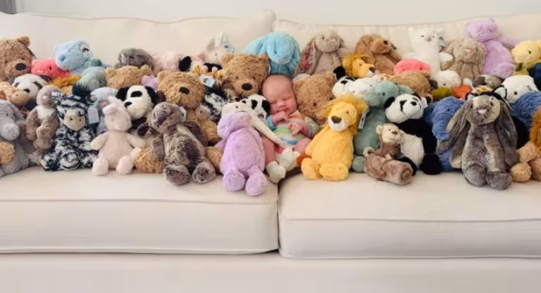 Baby Bodhi, surrounded by stuffed animals