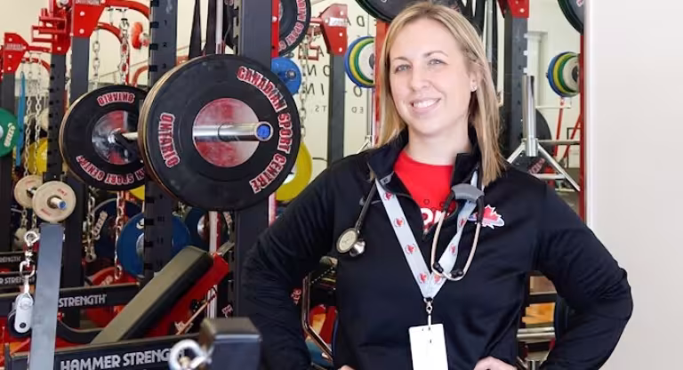 Dr. Kim Coros in front of athletic weight racks