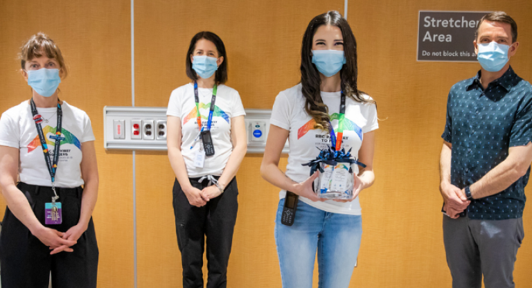 Four individuals wearing facemasks