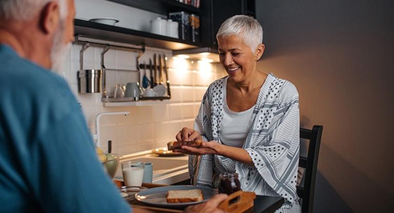 Two people prepare a meal together at a kitchen counter. 