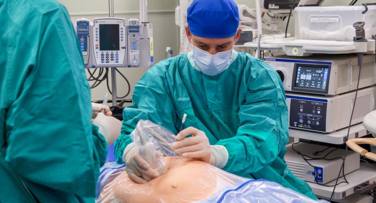A physician demonstrates the use of fetal ultrasound for a procedure. 