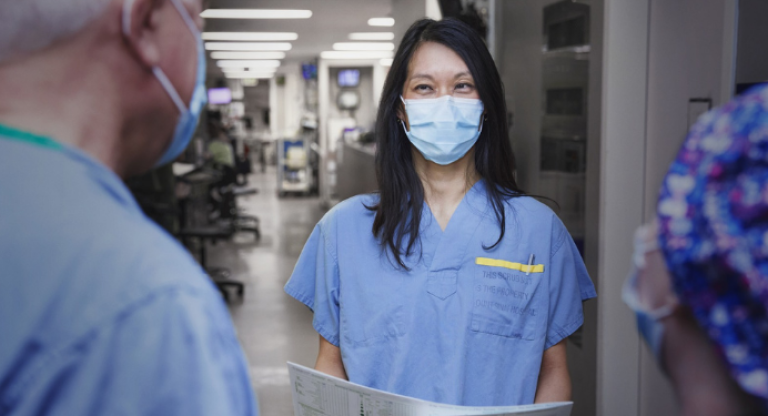 Dr. Christie Lee speaks with colleagues in the ICU.