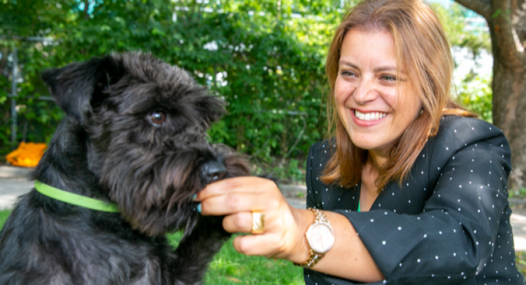 Dr. Caroline Kramer with her black miniature Schnauzer in the park.