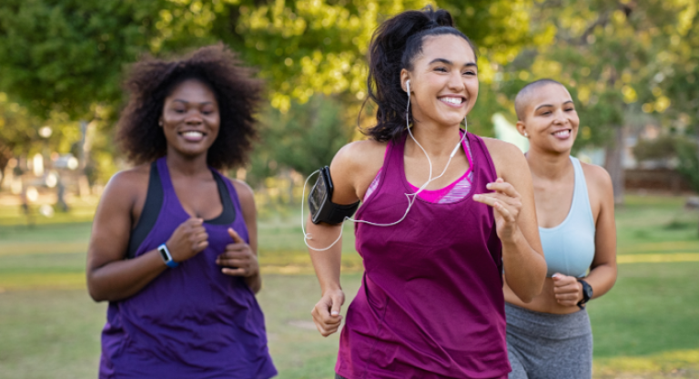 Three women running together outside.