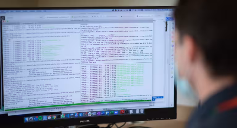 A Sinai Health researcher looking at computer code on his desktop