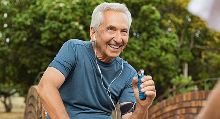 Elder man smiling using a hand-grip strengthener