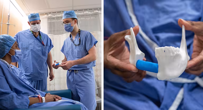Photo of surgeons with patient who is all gowned up holding a 3D printed version of her jaw. 