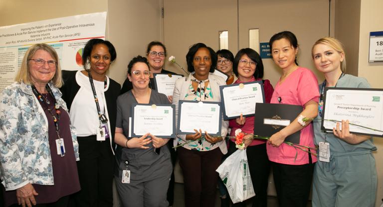 A group of nurses stand holding award certificates