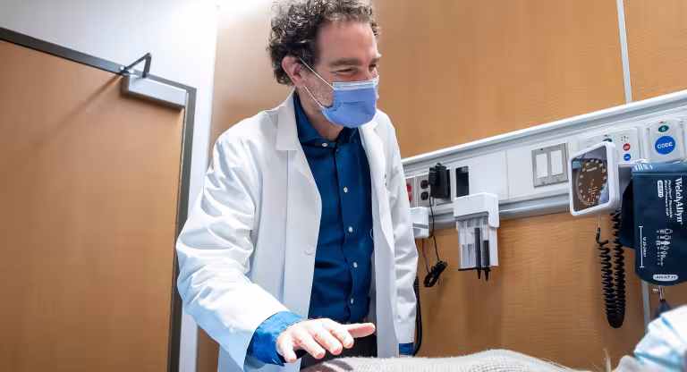 Picture of Dr. Adam Weizman who is examining a patient.