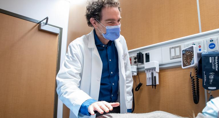 Picture of Dr. Adam Weizman who is examining a patient.