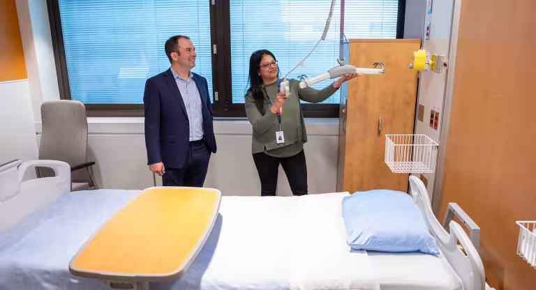 Two people in a hospital room in the general internal medicine unit. 