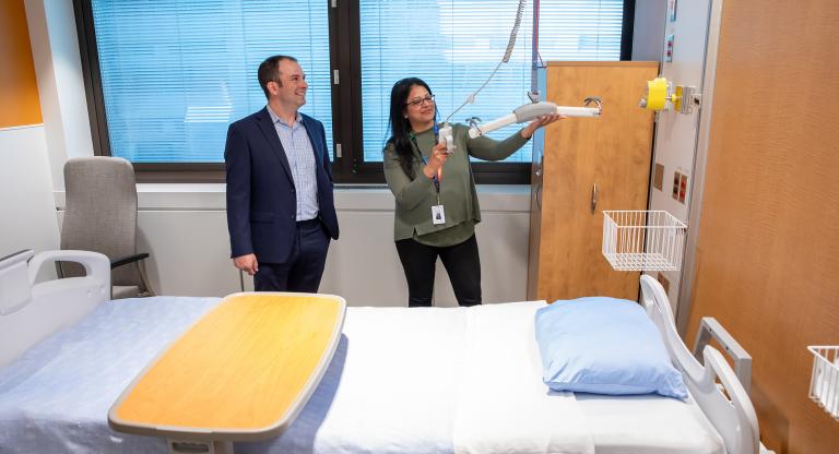 Two people in a hospital room in the general internal medicine unit. 