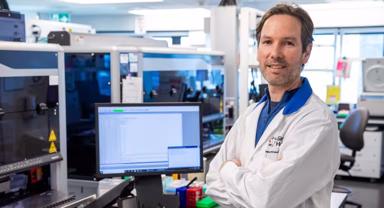 A photo of Sinai Health’s Dr. Jordan Lerner-Ellis in the lab with this arms crossed. 