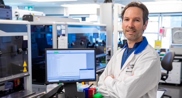 A photo of Sinai Health’s Dr. Jordan Lerner-Ellis in the lab with this arms crossed. 