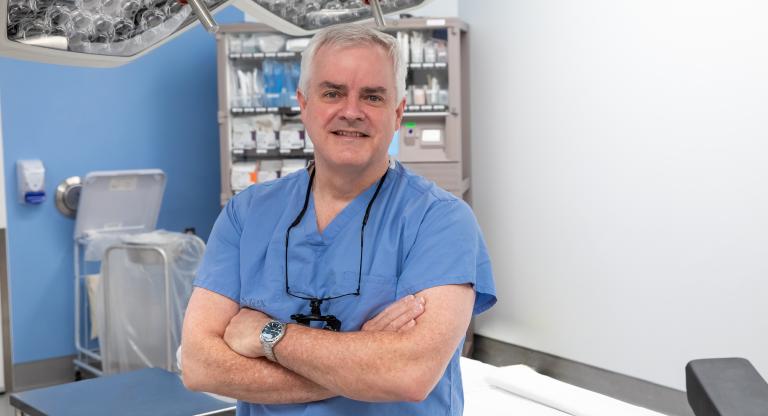 A photo of Dr. Ian Witterick, Sinai Health's surgeon-in-chief in a medical setting with this arms crossed 