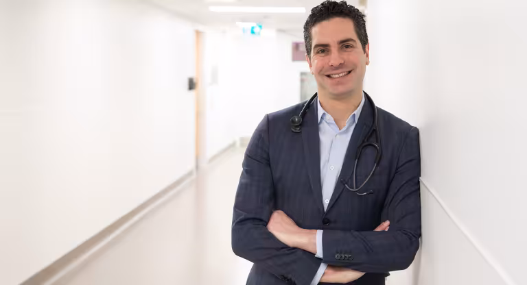 Dr. Nathan Stall in a blue suit and stethoscope.