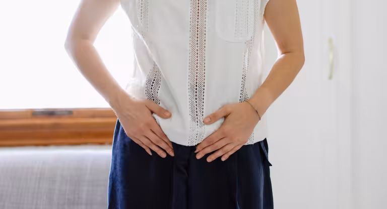 woman holds her abdomen 