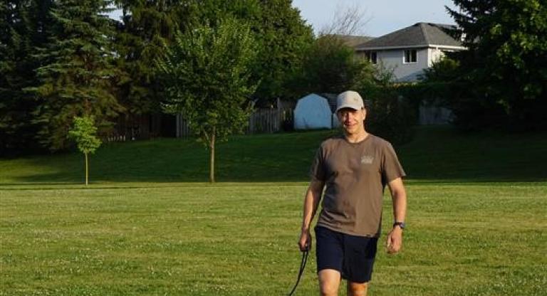 man walking in a field with dog
