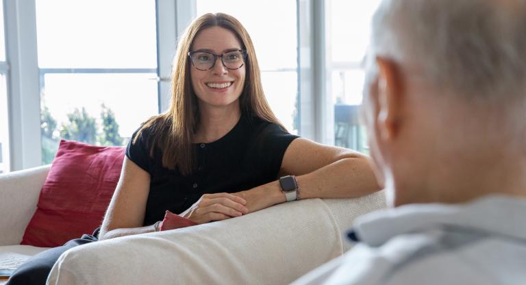 Dr. Marnie Howe sits with a patient during an at home palliative care visit.