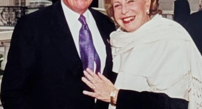 Smiling man and woman. Red banner with white text reads Jerry and Carole Grafstein