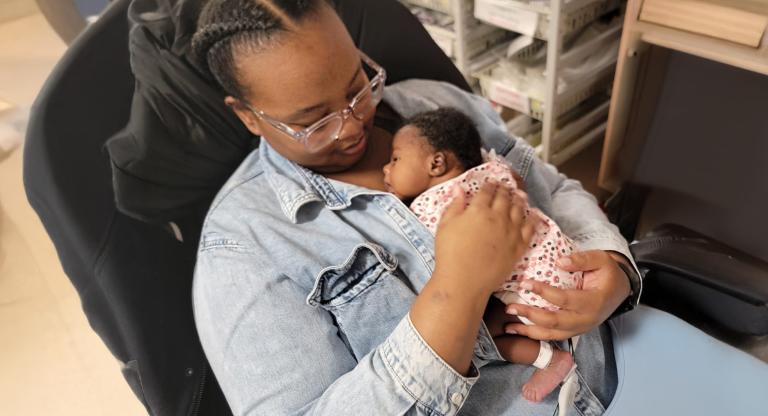 mother holds tiny baby against her chest