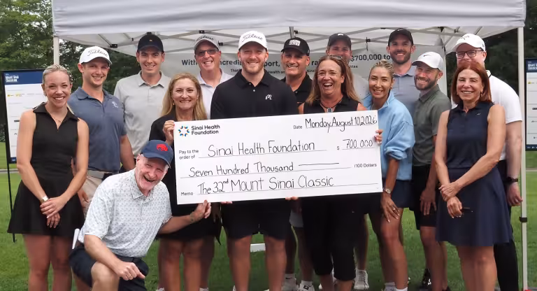 group stands with big cheque